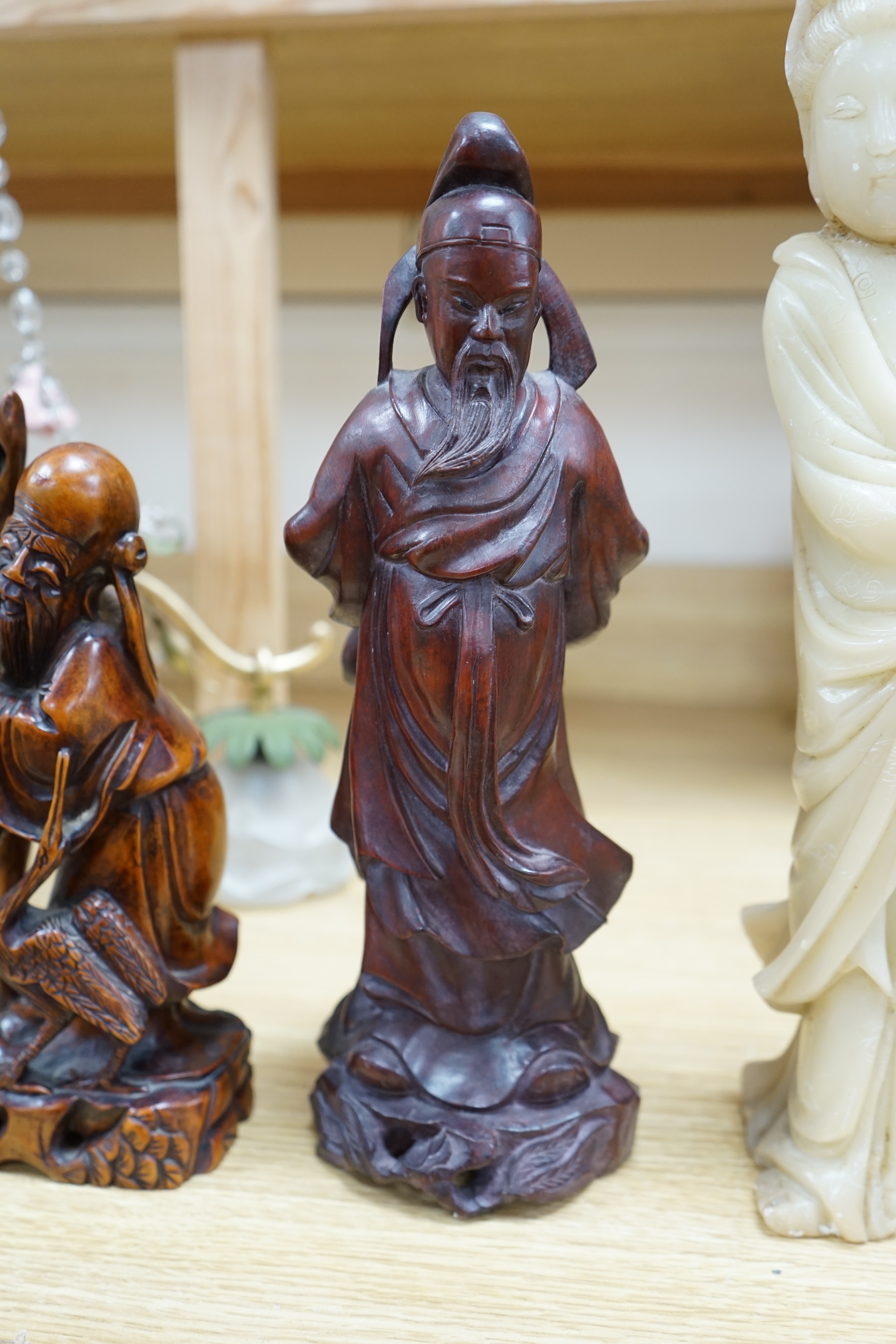 Two Chinese hardwood carved figures and a soapstone figure of Guanyin, largest 37cm high. Condition - fair